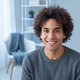 Headshot portrait of a smiling person in a modern home office, conveying trust and happiness.
